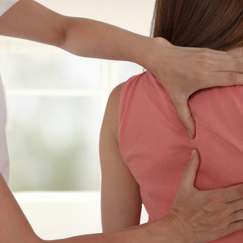 A person is receiving a neck or shoulder massage from another individual.